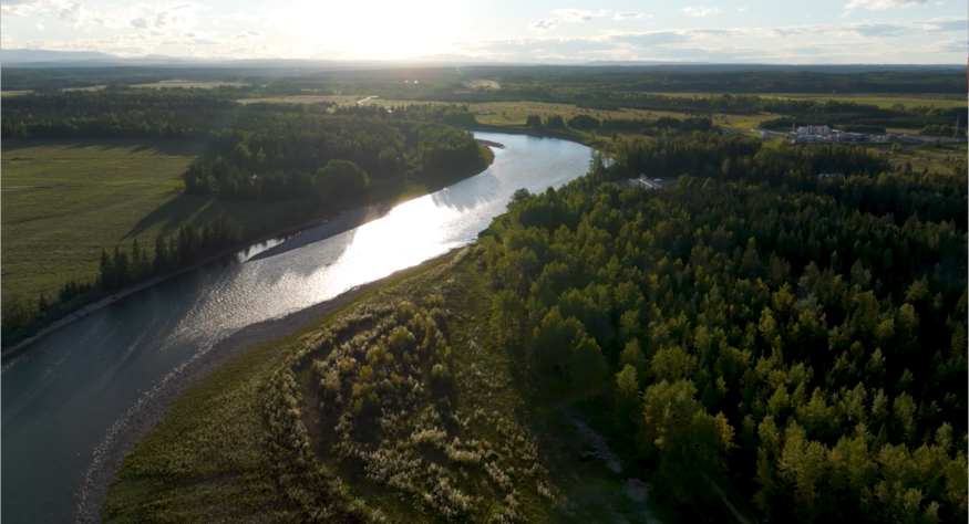 View of a river near sunset, surrounded by trees on either side.